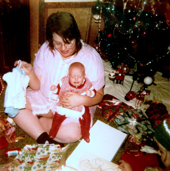 This is a restored family photo featuring a mama and baby on Christmas morning.